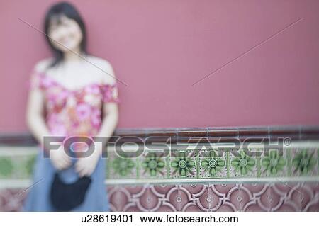 Young woman leaning against a wall View Large Photo Image Stock Image - Young woman leaning against a wall. Fotosearch