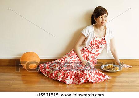 Young woman sitting on the floor with a plate of cake beside her View Large Photo Image Stock Photography - Young woman sitting on the floor with a plate of cake beside her. Fotosearch
