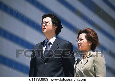 Bsinessman and businesswoman looking away, Low Angle View, View Large Photo Image Stock Photo - Bsinessman and businesswoman looking away, Low Angle View, . Fotosearch
