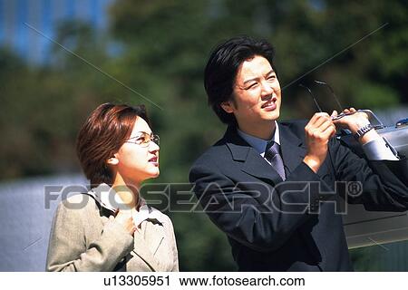 Stock Image - Businessman and businesswoman looking Away, Pin Focus. Fotosearch