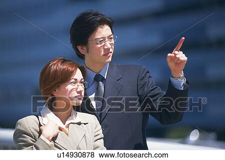 Businessman and businesswoman looking and pointing at something, Pin Focus View Large Photo Image Stock Photo - Businessman and businesswoman looking and pointing at something, Pin Focus. Fotosearch