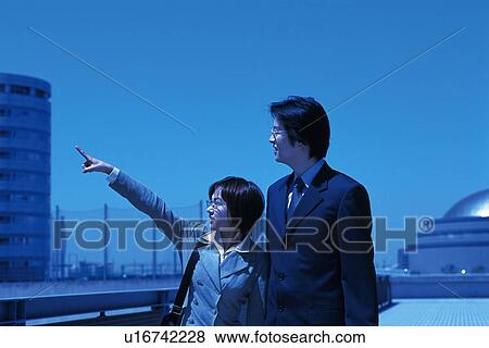 Businessman and businesswoman looking and pointing at something, Toned Image View Large Photo Image Stock Photo - Businessman and businesswoman looking and pointing at something, Toned Image. Fotosearch