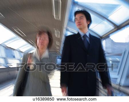 Businessman and businesswoman walking together, Blurred Motion View Large Photo Image Stock Image - Businessman and businesswoman walking together, Blurred Motion. Fotosearch
