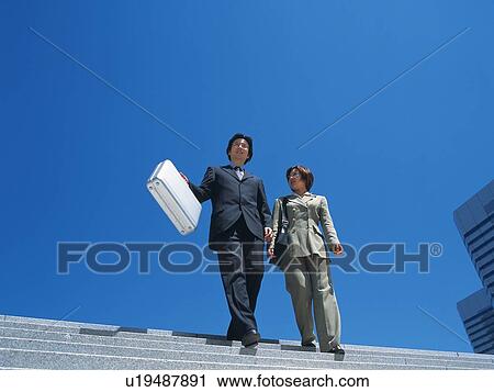 Businessman and businesswoman walking down the stairs, Low Angle View View Large Photo Image Stock Image - Businessman and businesswoman walking down the stairs, Low Angle View. Fotosearch