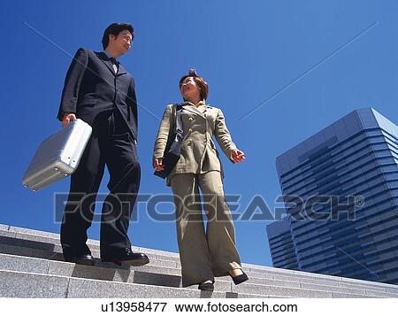 Businessman and businesswoman walking down the stairs, Low Angle View View Large Photo Image Stock Photo - Businessman and businesswoman walking down the stairs, Low Angle View. Fotosearch