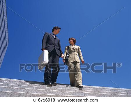Businessman and businesswoman walking down the stairs, Low Angle View View Large Photo Image Stock Photo - Businessman and businesswoman walking down the stairs, Low Angle View. Fotosearch