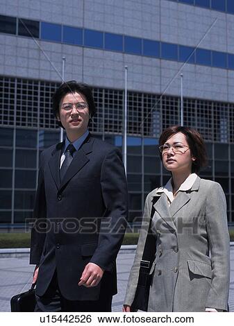 Businessman and businesswoman walking by the side of building, Front View View Large Photo Image Stock Photograph - Businessman and businesswoman walking by the side of building, Front View. Fotosearch