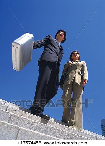 Businessman and businesswoman walking down the stairs, Low Angle View View Large Photo Image Stock Photograph - Businessman and businesswoman walking down the stairs, Low Angle View. Fotosearch