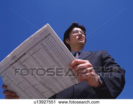 Businessman holding news paper, Low Angle View View Large Photo Image Stock Image - Businessman holding news paper, Low Angle View. Fotosearch