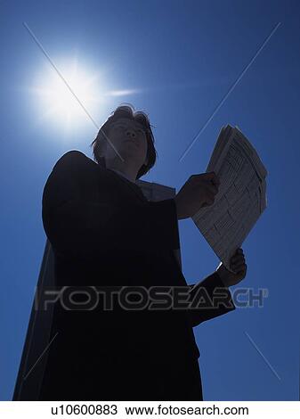 Businessman looking away and holding news paper, Low Angle View, Lens Flare View Large Photo Image Stock Image - Businessman looking away and holding news paper, Low Angle View, Lens Flare. Fotosearch