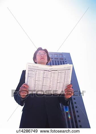 Businessman looking away and holding news paper, Low Angle View, Lens Flare, High Key View Large Photo Image Stock Photo - Businessman looking away and holding news paper, Low Angle View, Lens Flare, High Key. Fotosearch
