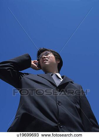 Businessman making call with mobile phone, Low Angle View View Large Photo Image Stock Image - Businessman making call with mobile phone, Low Angle View. Fotosearch