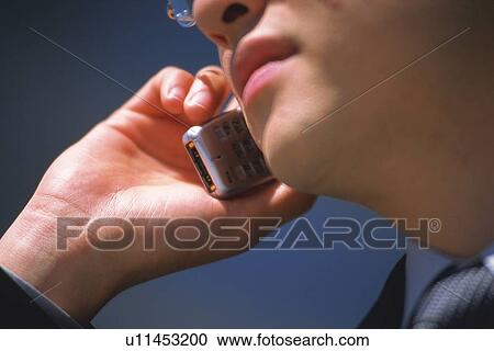 Stock Image - Businessman using mobile phone, Close Up. Fotosearch