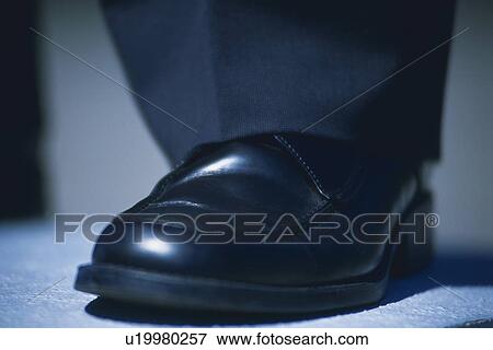 Stock Photo - Foot wearing leather shoe, Close Up. Fotosearch