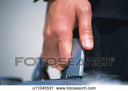 Stock Image - Hand holding business case, Close Up. Fotosearch
