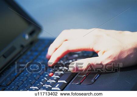 Stock Image - Hand typing keyboard, Side View. Fotosearch