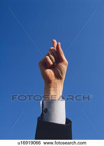Stock Photograph - Raised hand with index finger pointing up, Low Angle View. Fotosearch