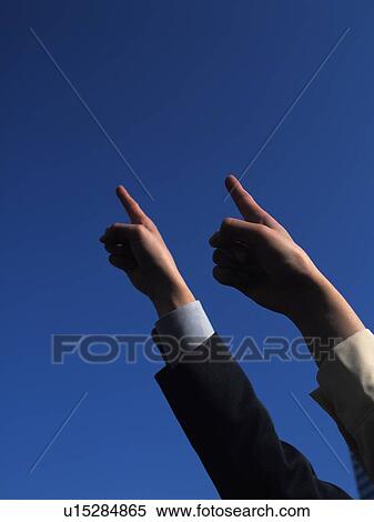 Two raised hands with index fingers pointing up, Low Angle View View Large Photo Image Stock Photography - Two raised hands with index fingers pointing up, Low Angle View. Fotosearch