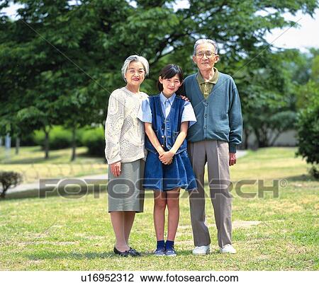 Senior adult man and woman standing together with a granddaughter, Front View View Large Photo Image Stock Image - Senior adult man and woman standing together with a granddaughter, Front View. Fotosearch