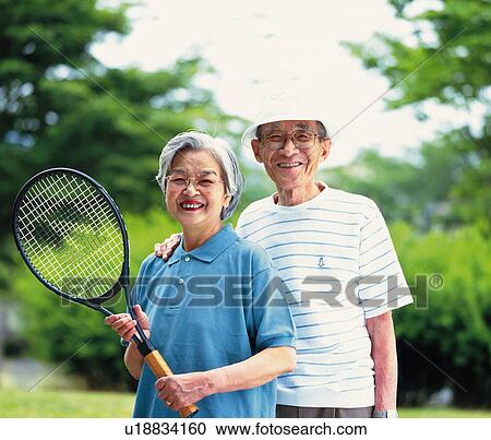 Senior adult man and woman standing with a tennis racket, Front View View Large Photo Image Stock Image - Senior adult man and woman standing with a tennis racket, Front View. Fotosearch