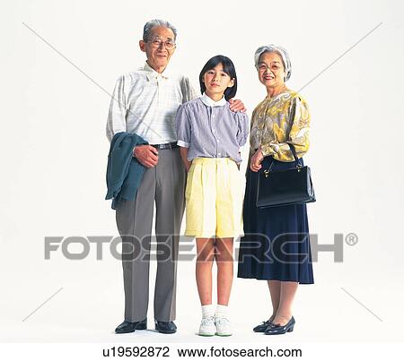 Stock Image - Senior adult man and woman standing together with a granddaughter, Front View. Fotosearch