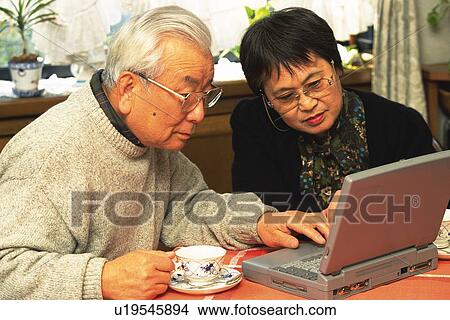 Senior adult man and woman using a laptop computer, High Angle View View Large Photo Image Picture - Senior adult man and woman using a laptop computer, High Angle View. Fotosearch