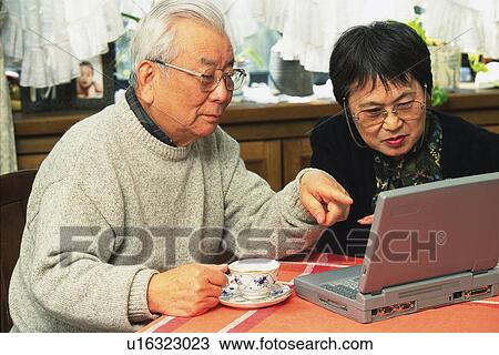 Stock Image - Senior adult man and woman using a laptop computer, High Angle View. Fotosearch