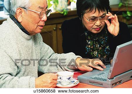 Senior adult man and woman using a laptop computer, High Angle View View Large Photo Image Stock Photo - Senior adult man and woman using a laptop computer, High Angle View. Fotosearch