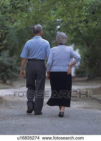 Picture - Senior adult man and woman walking together, Rear View. Fotosearch