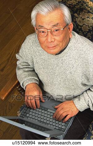 Senior adult man looking at camera with a laptop computer, High Angle View View Large Photo Image Picture - Senior adult man looking at camera with a laptop computer, High Angle View. Fotosearch