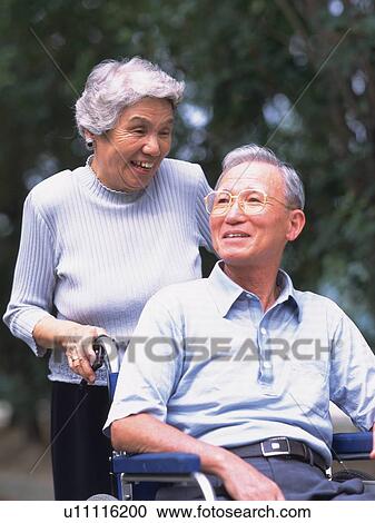 Senior adult man on a wheelchair and his wife pushing it, Front View View Large Photo Image Stock Image - Senior adult man on a wheelchair and his wife pushing it, Front View. Fotosearch