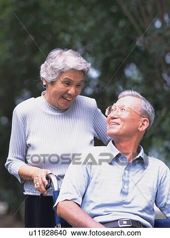 Senior adult man on a wheelchair and his wife pushing it, Front View View Large Photo Image Stock Image - Senior adult man on a wheelchair and his wife pushing it, Front View. Fotosearch