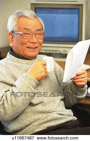Senior adult man smiling at camera with documents and a cup in hands, Side View View Large Photo Image Stock Photo - Senior adult man smiling at camera with documents and a cup in hands, Side View. Fotosearch