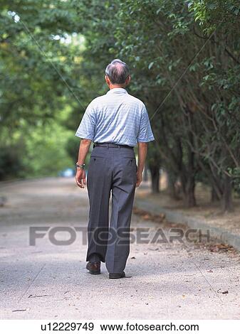 Stock Photo - Senior adult man taking a walk, Rear View. Fotosearch