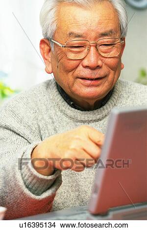 Picture - Senior adult man using a laptop computer, Front View. Fotosearch