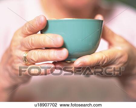 Senior adult woman holding a tea cup in hands, Close Up View Large Photo Image Stock Image - Senior adult woman holding a tea cup in hands, Close Up. Fotosearch