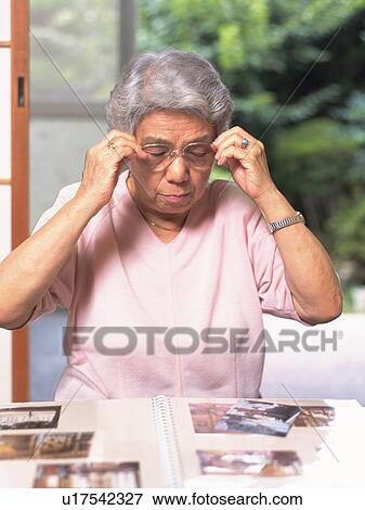 Senior adult woman looking at pictures, Front View View Large Photo Image Stock Photo - Senior adult woman looking at pictures, Front View. Fotosearch