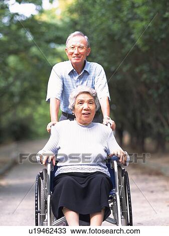 Senior adult woman on a wheelchair and her husband pushing it, Front View View Large Photo Image Stock Image - Senior adult woman on a wheelchair and her husband pushing it, Front View. Fotosearch