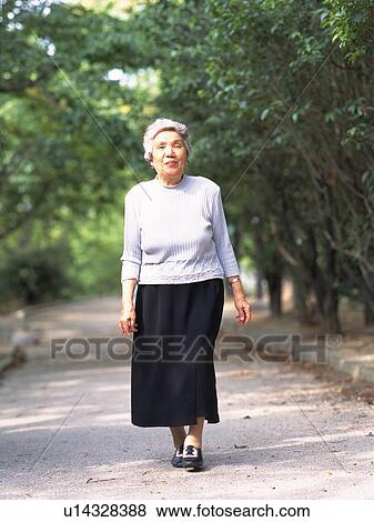 Stock Photo - Senior adult woman taking a walk, Front View. Fotosearch