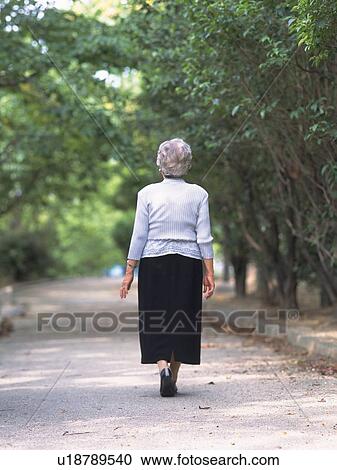 Stock Image - Senior adult woman taking a walk, Rear View. Fotosearch