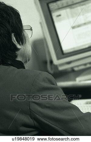 Stock Photo - Senior adult woman using a computer, Rear View, Black and White. Fotosearch
