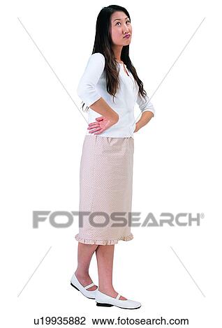 Stock Image - Casual Clothing, Looking Up, Hand On Hip, Asian, Indoor. Fotosearch