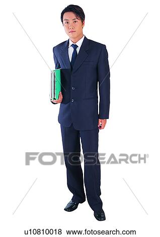 Stock Photo - Looking At Camera, Business Suit, Holding, Businessman, One Young Man Only, Asian Ethnicity, Young Adult. Fotosearch