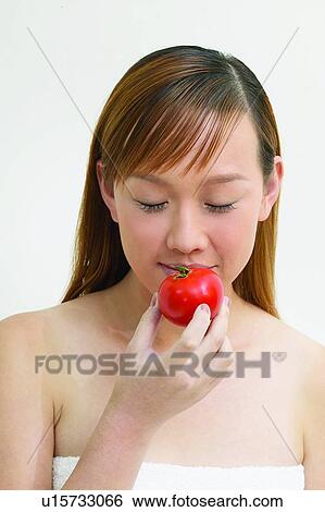 Stock Photograph - One Young Woman Only, Beauty & Fruits, Bangs, Eastern, Holding, Eyes Closed. Fotosearch
