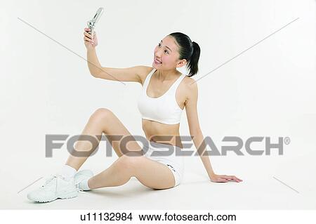 Picture - Sitting, Happiness, One Young Woman Only, Sports Clothing, Ponytail. Fotosearch