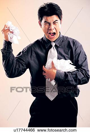 Stock Photograph - standing, lifestyle, discomfort, business attitudes, fashion, papers. Fotosearch