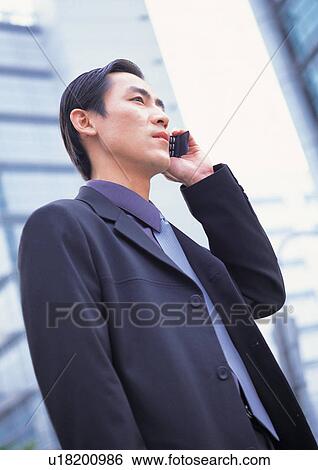 Stock Photograph - business executive, on the phone, man only, outdoor, building exterior, formal. Fotosearch