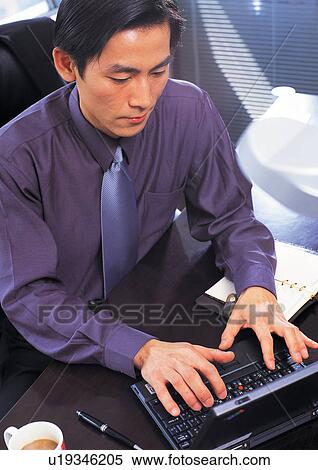 Stock Photography - business in asia, looking down, formal, well dressed, indoor, asian ethnicity, tie. Fotosearch