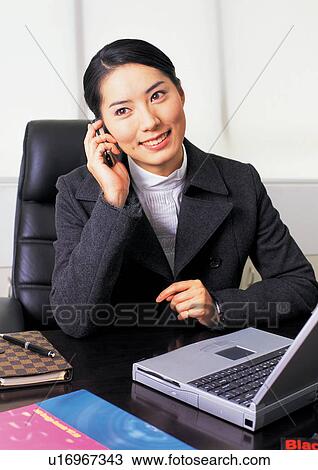 Stock Image - connectivity, asian ethnicity, on the phone, profession, half length, communication, waist-up. Fotosearch