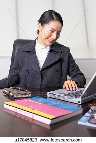 Stock Image - professional, office, woman only, young adult, book, office desk. Fotosearch